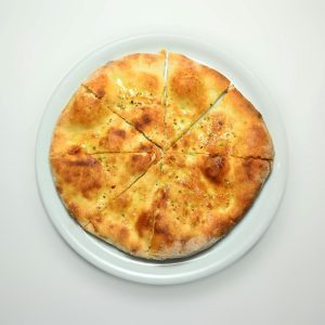 Golden hot focaccia bread topped with herbs, perfect for a delicious meal.