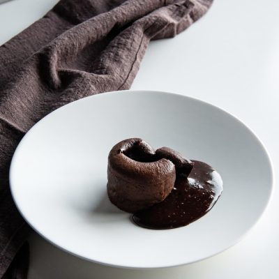 a white plate topped with two chocolate donuts