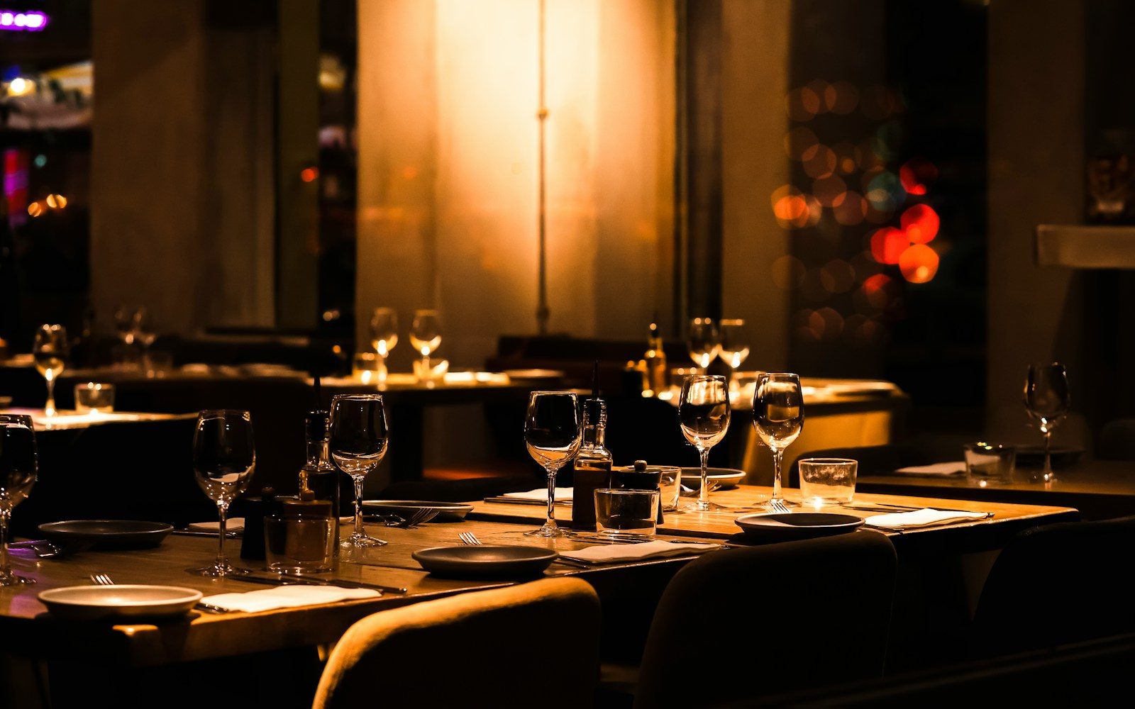 A dimly lit restaurant with empty tables and chairs